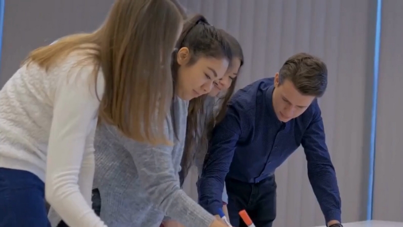 Four Colleagues Collaborate on A Whiteboard in A Modern Office