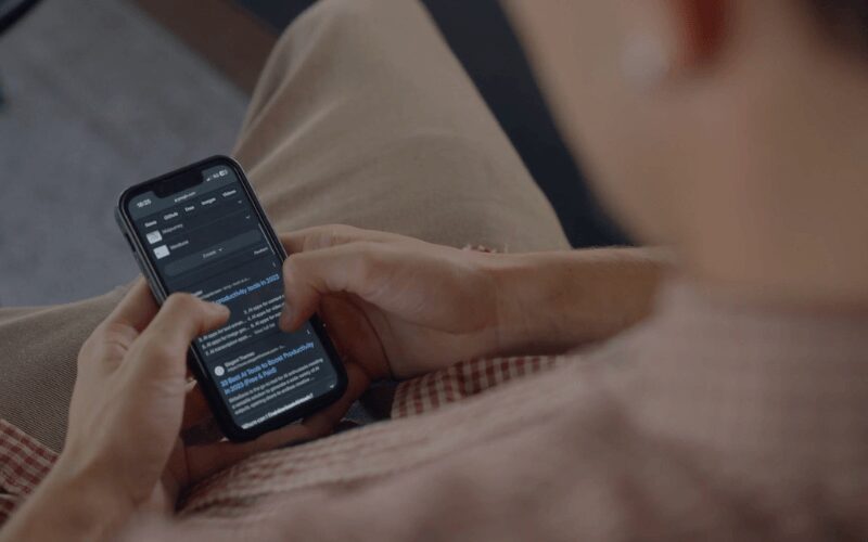 Person holding a smartphone and browsing online search results