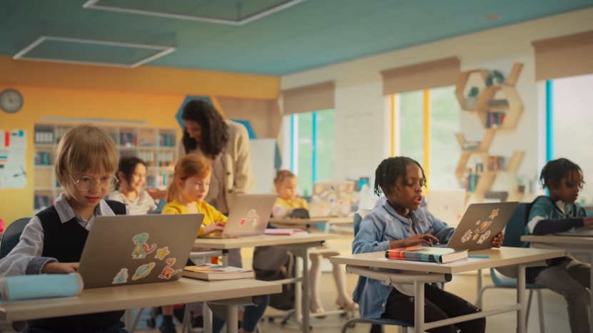 A Classroom of Children Using Laptops with A Teacher Assisting, Representing AI-Powered Personalization in Learning
