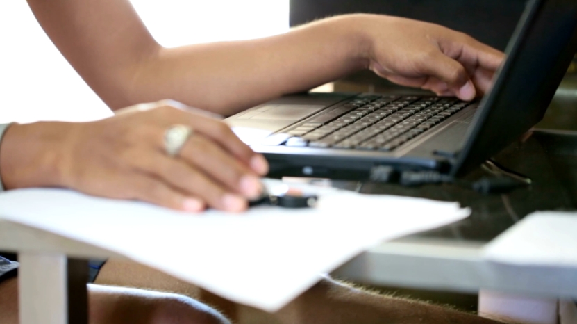 A student uses a laptop and notes, showing how check-ins support academic integrity