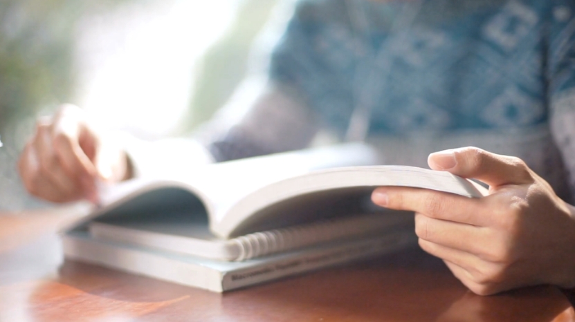 A person studies alone, reading a textbook without taking any breaks or resting