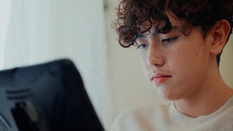 A student looks at a tablet alone, studying without taking time to review or reflect on the material
