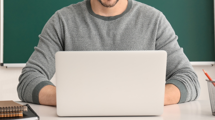 A man sits at a desk with a laptop, preparing tips for building effective Kahoot! quizzes