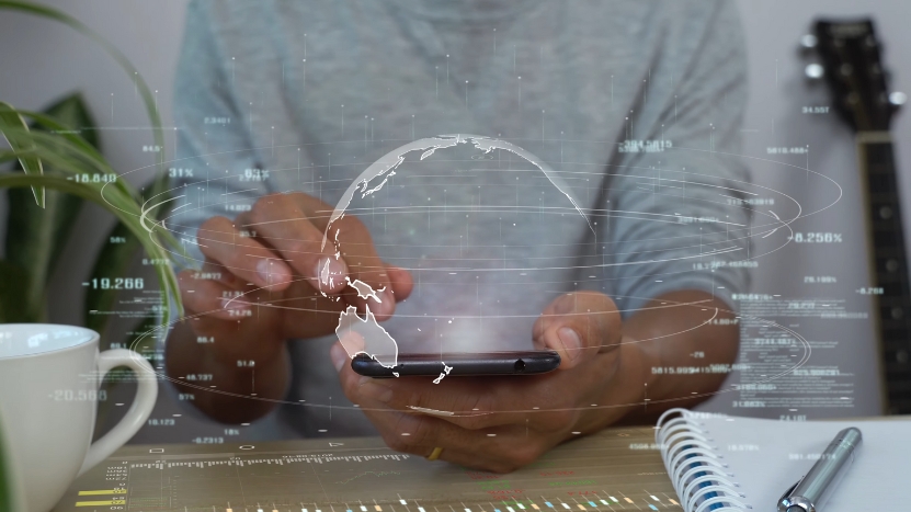 A man uses a smartphone with a digital globe overlay, representing online tutoring