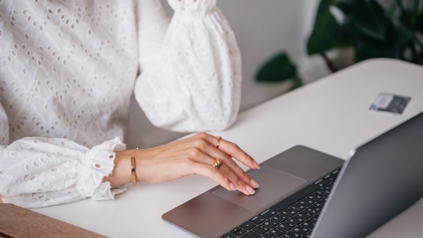 A teacher uses a laptop to manage communication with families and staff through automation tools
