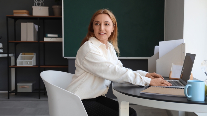 A teacher uses a laptop in the classroom to support learning and well-being