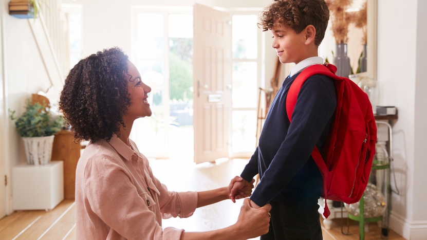 A mother helps her son with a backpack, showing a moment of getting your kid ready for school