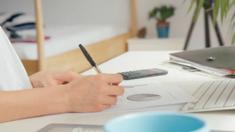 Person reviewing documents and graphs at a desk for postgraduate degrees research