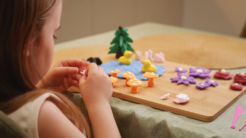 Child creating clay figures at home as part of afterschool activities