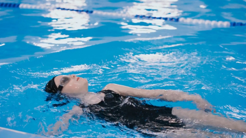 A child floats on their back in a swimming pool during practice